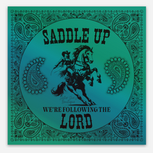 Sticker design with text 'Saddle Up We're Following the Lord' on a holographic turquoise background.
